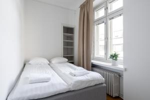 a white bedroom with a large bed with white pillows at 2ndhomes Tampere 2BR "Tuulensuu" Apt - Sauna, Historical Building & Great Location in Tampere