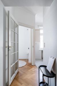 a white room with a glass door and a table at 2ndhomes Tampere 2BR "Tuulensuu" Apt - Sauna, Historical Building & Great Location in Tampere