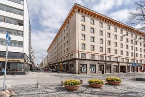a large building on a city street with flower pots at 2ndhomes Tampere 2BR "Tuulensuu" Apt - Sauna, Historical Building & Great Location in Tampere