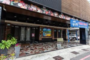 un edificio con un cartello di fronte di I HI Sanduo Travel Hotel a Kaohsiung