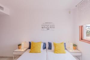 a white couch with yellow pillows in a room at Andaluz Apartments Mar de Nerja in Nerja