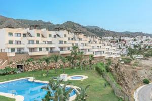 un gran edificio de apartamentos en una colina con piscina en Andaluz Apartments Mar de Nerja, en Nerja