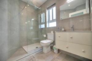 a bathroom with a toilet and a glass shower at Seaside apartment in the heart of Xlendi Gozo in Xlendi