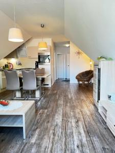 an open living room with a table and chairs at Charlys grode Stuv in Wustrow +3 photos