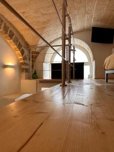 una grande camera con pavimento in legno e scala di L'Antica Dimora in Centro a Bari