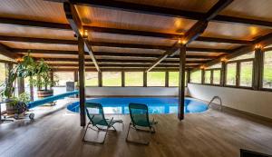 a swimming pool in a house with two chairs at PENSIUNEA SKY HUB in Arieşeni