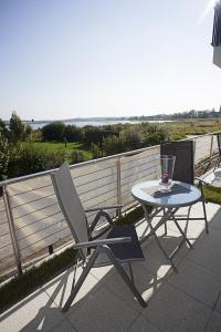 einen Tisch und einen Stuhl auf einer Terrasse mit Meerblick in der Unterkunft Residenz am Balmer See - BS 01 mit Wellnessbereich in Balm