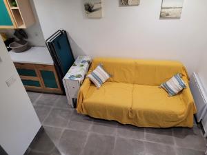 ein Schlafzimmer mit einem Bett mit einer gelben Decke in der Unterkunft Mini villa au bord de la mer, proche Moriani (Corse) in Poggio-Mezzana