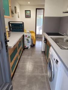 eine Küche mit Waschmaschine und Trockner im Zimmer in der Unterkunft Mini villa au bord de la mer, proche Moriani (Corse) in Poggio-Mezzana