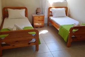 1 dormitorio con 2 camas individuales y mesita de noche en 'Magic Of Nature' Cottage With a Breathtaking View, en Dhriópi