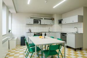 a kitchen with a white table and green chairs at micampus Covilhã in Covilhã