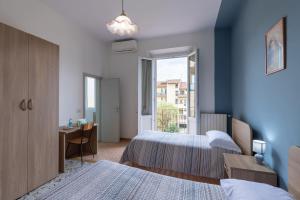佛羅倫斯的住宿－Antica Dimora Sant'Anna，一间卧室设有两张床、一张桌子和一个窗口。