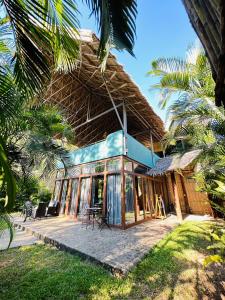 a house with a thatched roof with a patio at Buko Beach Resort in El Nido