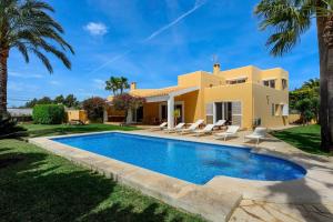 a villa with a swimming pool in front of a house at Villa Cali in Sant Josep de sa Talaia