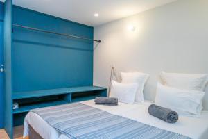 ein Schlafzimmer mit einer blauen Wand und einem Bett mit zwei Kissen in der Unterkunft CASA RIETSCH in Matosinhos