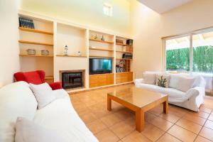 a living room with two white couches and a tv at Villa Cali in Sant Josep de sa Talaia