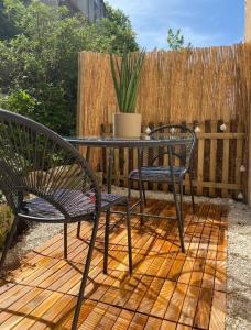 a patio with two chairs and a table and a fence at Appartement avec terrasse in Quimper