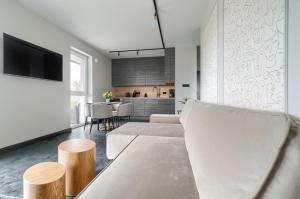 a living room with a couch and a kitchen at Bridge Apartments & Spa Dziwnów in Dziwnów