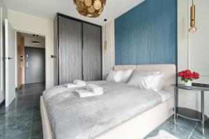 a bedroom with a large bed with two towels on it at Bridge Apartments & Spa Dziwnów in Dziwnów