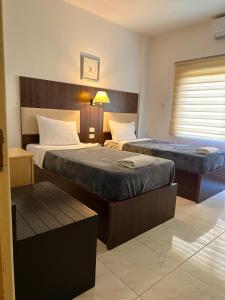 Habitación de hotel con 2 camas y ventana en Petra Town Check-Inn en Wadi Musa