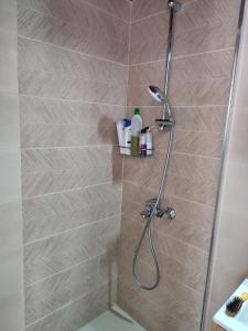 uma casa de banho com um chuveiro e uma porta de vidro em Perseids Traditional House em Amorgós