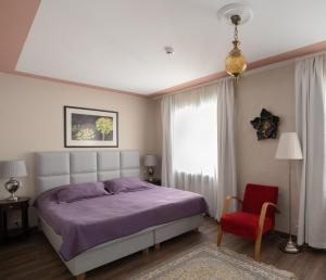 里加圣彼得精品酒店的一间卧室，有一张床和一把红椅子