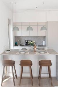 uma cozinha com uma ilha com dois bancos e um balcão em Bright apartment in the New building (FORM_F1) em Atenas