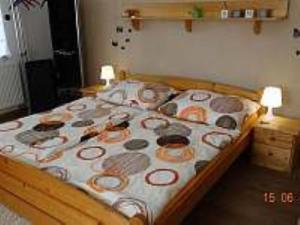 um quarto com uma cama de madeira com almofadas em Chalupa Pod lesem em Telč