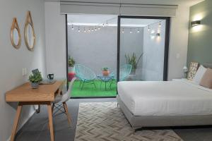 a bedroom with a bed and a table and chairs at NIU Modern & Centric Lofts in Mexico City