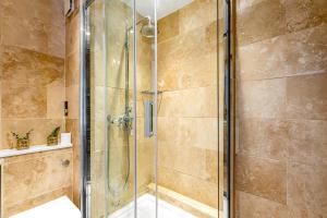 a shower with a glass door in a bathroom at Charming Studio Flat next to Holborn station in London