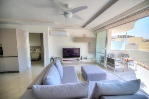 a living room with a couch and a tv at Seaside apartment in the heart of Xlendi Gozo in Xlendi