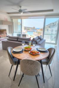 a dining room with a table and chairs and a couch at Seaside apartment in the heart of Xlendi Gozo in Xlendi