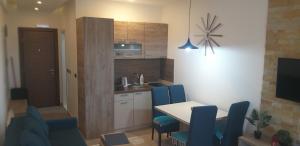 a kitchen with a table and blue chairs in a room at Ogy's apartment in Kopaonik