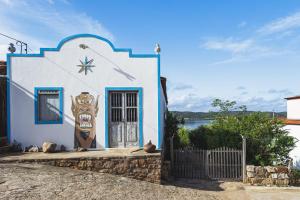 a blue and white building with a door and a fence at Casa da Estrelinha - Ilha do Ferro in Gentileza