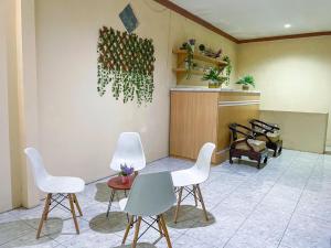 a waiting room with white chairs and a table at Kinari Sharia Living in Kediri