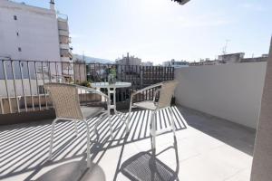 um pátio com 2 cadeiras e uma mesa na varanda em Bright apartment in the New building (FORM_F1) em Atenas