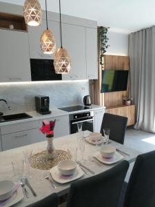 a kitchen with a table with plates and wine glasses at Apartament Zielone Wzgórze 2 in Jelenia Góra