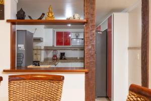 uma cozinha com electrodomésticos vermelhos e brancos num quarto em Praia da Ferradura com quatro suítes e piscina. em Búzios