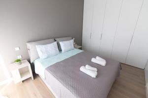 um quarto com uma cama com duas toalhas brancas em Bright apartment in the New building (FORM_F1) em Atenas