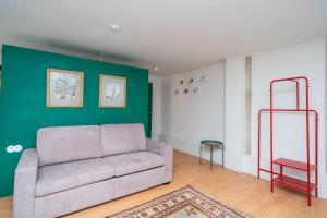 a living room with a couch and a green wall at CASA RIETSCH in Matosinhos