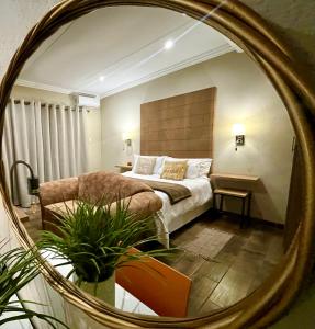um quarto com uma cama e um espelho em Swane’s guesthouse em Rustenburg