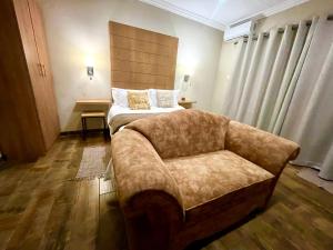 um quarto com um sofá, uma cama e uma cadeira em Swane’s guesthouse em Rustenburg