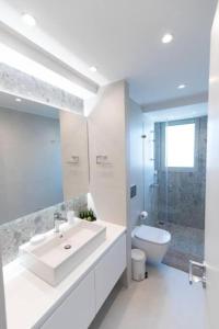 uma casa de banho branca com um lavatório e um WC em Bright apartment in the New building (FORM_F1) em Atenas