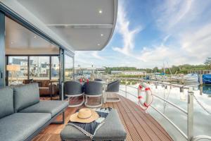 een terras van een boot met een bank en stoelen bij Chalet am Meer in Peenemünde