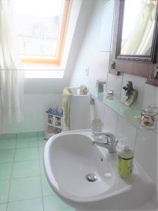 łazienka z białą umywalką i oknem w obiekcie Dom & ses chambres d'hôtes w mieście Plouigneau +9 zdjęć