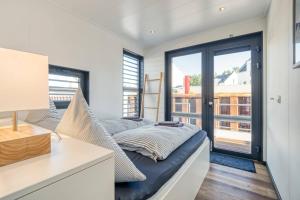 een slaapkamer met een bed met kussens erop bij Chalet am Meer in Peenemünde