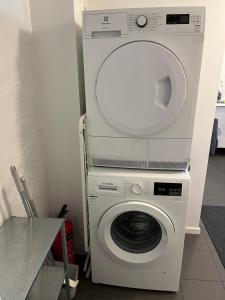 a white washer and dryer in a room at Central living with many beds and private garden! in Gothenburg