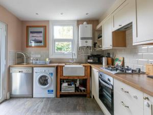 a kitchen with a washing machine and a sink at Cute and Cosy 2 Bed on a Peaceful street in Kent
