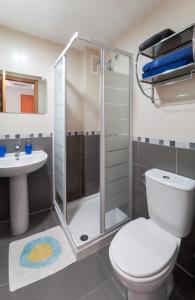 een badkamer met een douche, een toilet en een wastafel bij AG RESIDENCIAL EL EDEN in Playa de Gandia