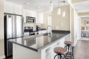 a kitchen with a stainless steel refrigerator and two bar stools at La Jolla 1br w gym wd pool nr bars shops SAN-7 in San Diego